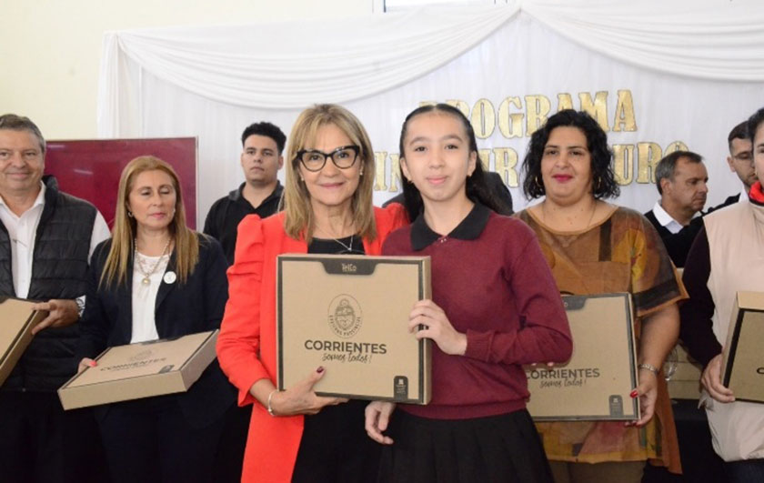 Ministra de Educación Práxedes López entregando notebook a alumna de secundaria