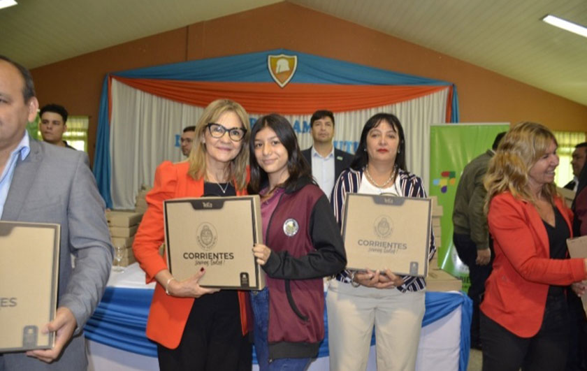 Ministra de Educación Práxedes López entregando notebook a alumna de secundaria