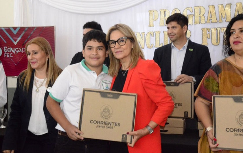 Ministra de Educación Práxedes López entregando notebook a alumno de secundaria