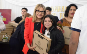 Ministra de Educación Práxedes López entregando notebook a alumna de secundaria