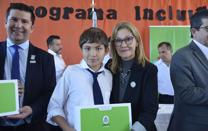 Ministra Práxedes López con alumno, entregando netbook