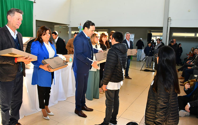 Valdés entregando notebook a alumno